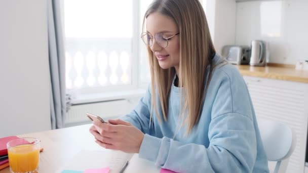 Soustředěná Mladá Blondýnka Brýlemi Píše Svém Smartphonu Jak Sedí Doma — Stock video