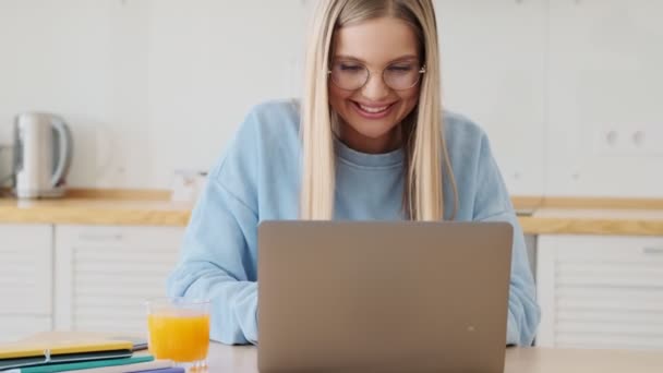 Una Joven Rubia Feliz Satisfecha Usando Gafas Está Usando Computadora — Vídeos de Stock