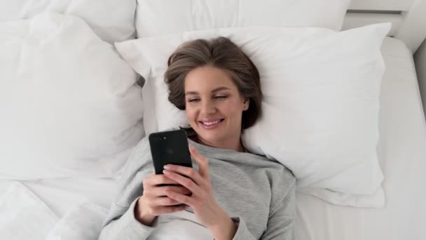 Una Joven Feliz Sonriente Está Viendo Algo Bueno Teléfono Inteligente — Vídeos de Stock