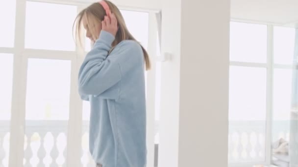 Привлекательная Молодая Блондинка Танцует Слушая Музыку Гостиной Дома — стоковое видео