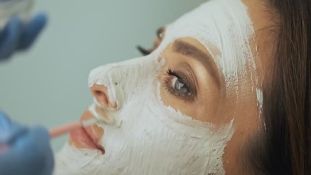 一位专业的医生 美容师正在美容院为女性顾客戴口罩 — 图库视频影像