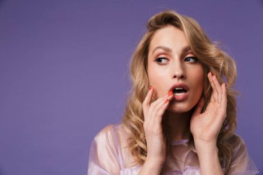 Çekici bir kadın görüntüsü. Mor arka planda izole edilmiş poz veriyor ve yan bakıyor.