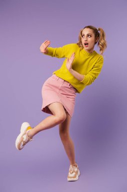 İki kuyruklu korkmuş güzel bir kadının görüntüsü mor arka planda izole edilmiş dur hareketi yapıyor.