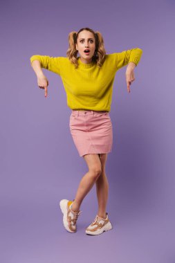 Şok olmuş, iki kuyruğu aşağıya bakan, mor arka planda soyutlanmış güzel bir kadın resmi.