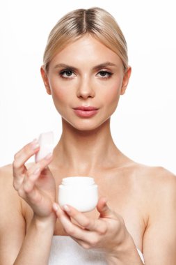 Beyaz arka planda izole edilmiş yüz kremiyle poz veren güzel üstsüz kadın resmi