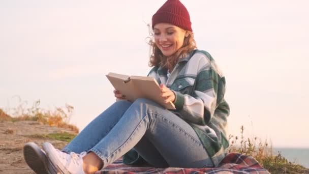 Mulher Loira Alegre Usando Chapéu Xadrez Livro Leitura Camisa Enquanto — Vídeo de Stock