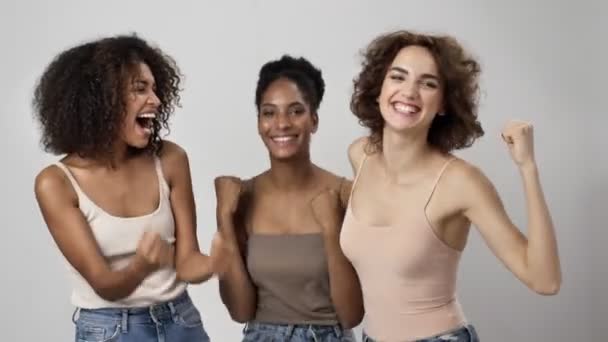 三位快乐的多民族女性正在做优胜的姿态 并为与白人背景隔离而欢欣鼓舞 — 图库视频影像