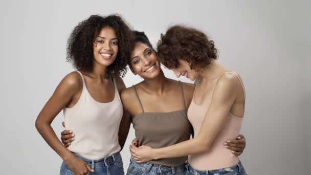 Tre Vänliga Multietniska Kvinnor Kramas Tillsammans Isolerad Över Vit Bakgrund — Stockvideo