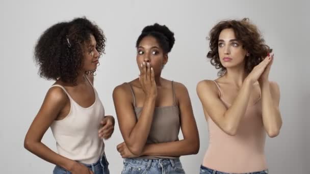 Tre Attraktiva Multietniska Kvinnor Sprider Rykten Varandra Isolerade Över Vit — Stockvideo