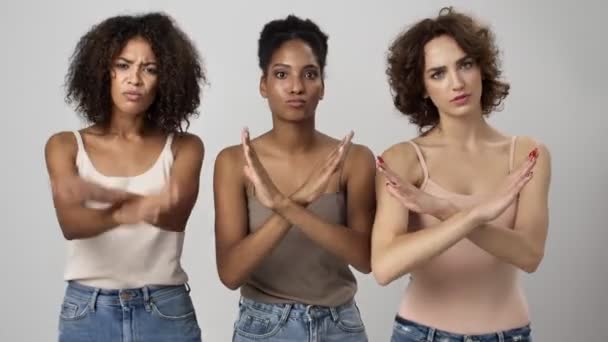 三つの深刻な多民族の女性は白い背景に隔離された交差手でジェスチャーしながらなしジェスチャーを示しています — ストック動画