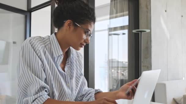 Una Joven Tranquila Empresaria Africana Está Mirando Teléfono Inteligente Mientras — Vídeo de stock