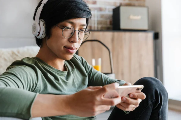 Beeld Van Knappe Jonge Aziatische Man Het Dragen Van Koptelefoon — Stockfoto