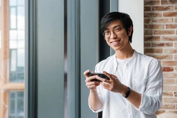 Imagen Hombre Asiático Joven Guapo Con Anteojos Sosteniendo Teléfono Celular — Foto de Stock