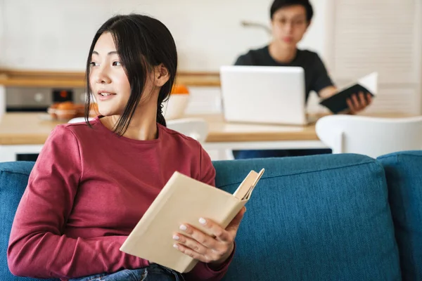 Foto Unga Koncentrerade Asiatiska Par Läsa Böcker Och Använda Laptop — Stockfoto