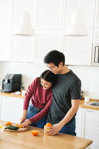 스러운 동양인 주방에서 식사를 준비하고 오렌지를 껴안고 — 스톡 사진