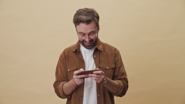 Een Opgewonden Gefocuste Jonge Ongeschoren Man Speelt Games Zijn Smartphone — Stockvideo