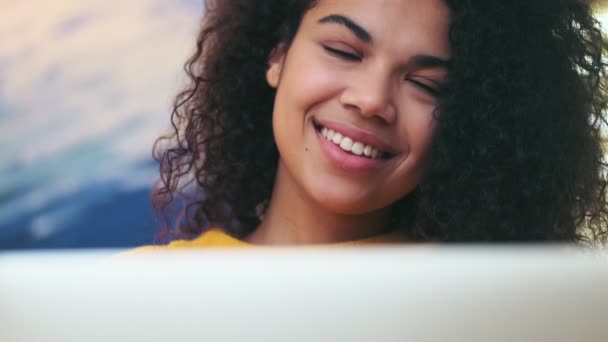 Sorrindo Mulher Atraente Africano Pensativo Usando Computador Portátil Enquanto Sentado — Vídeo de Stock