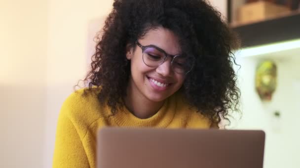 坐在室内椅子上 戴着眼镜 用手提电脑 快乐而有魅力的非洲女人 — 图库视频影像