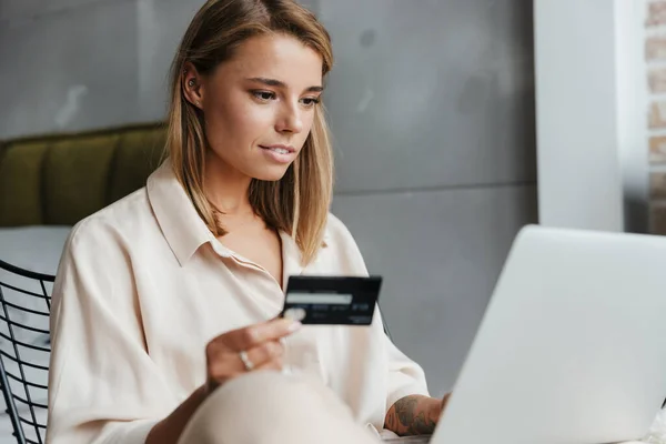 Imagen Una Agradable Mujer Enfocada Pijamas Sosteniendo Tarjeta Crédito Usando — Foto de Stock