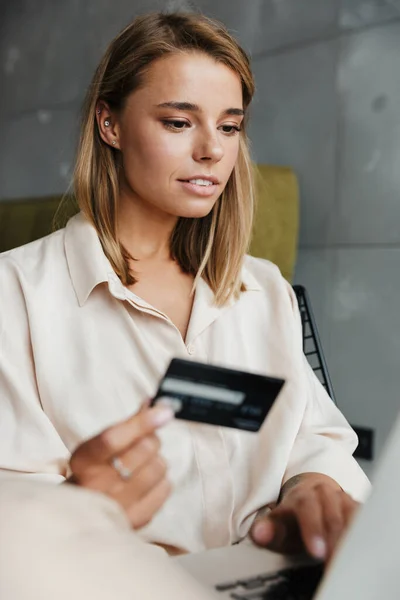 Imagen Una Agradable Mujer Enfocada Pijamas Sosteniendo Tarjeta Crédito Usando —  Fotos de Stock