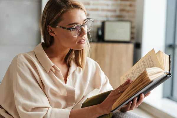 Image Serious Nice Woman Eyeglasses Reading Book While Sitting Sofa — Stock Photo, Image