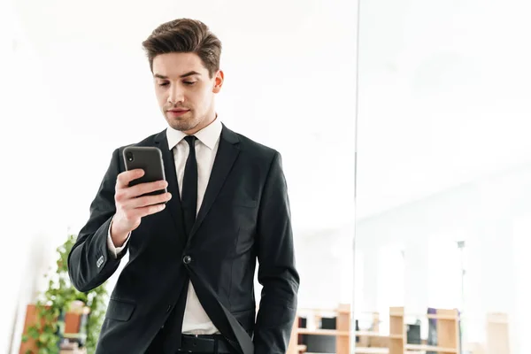 Image Serious Young Businessman Wearing Black Suit Using Mobile Phone — Stock Photo, Image