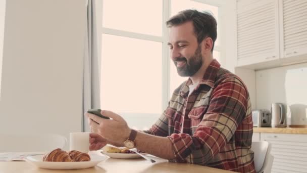 Yakışıklı Olumlu Iyimser Sakallı Bir Adam Evdeki Mutfakta Cep Telefonu — Stok video