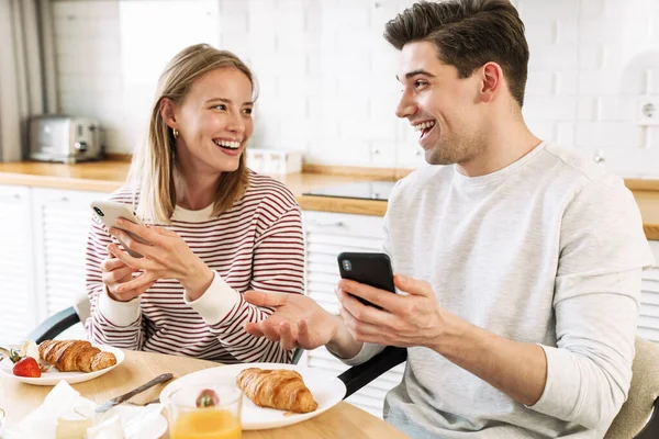 Retrato Pareja Sonriente Usando Teléfonos Inteligentes Hablando Mientras Desayunaba Acogedora — Foto de Stock