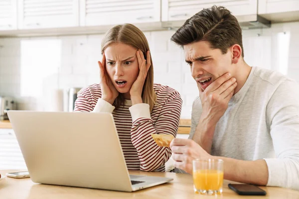 Portret Wystraszonej Pary Korzystającej Laptopa Trzymającej Kartę Kredytową Kuchni Domu — Zdjęcie stockowe