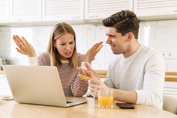 Portret Niezadowolonej Pary Korzystającej Laptopa Trzymającej Kartę Kredytową Podczas Siedzenia — Zdjęcie stockowe