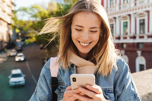 Gyönyörű Vidám Fiatal Szőke Visel Farmer Kabát Séta Városban Mobiltelefon — Stock Fotó