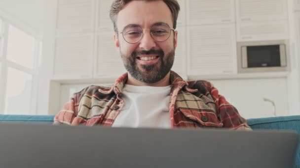 Handsome Young Positive Cheery Bearded Man Indoors Home Sitting Sofa — Stock Video