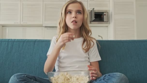 Een Lief Klein Meisje Eet Popcorn Terwijl Thuis Kijkt Woonkamer — Stockvideo