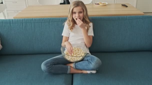 Ein Schönes Kleines Mädchen Isst Popcorn Während Sie Hause Wohnzimmer — Stockvideo