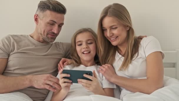 Eine Positiv Aussehende Familie Beobachtet Etwas Lustiges Auf Dem Smartphone — Stockvideo