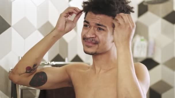 Mladý Pohledný Negativní Naštvaný Africký Chlap Při Pohledu Jeho Vlasy — Stock video
