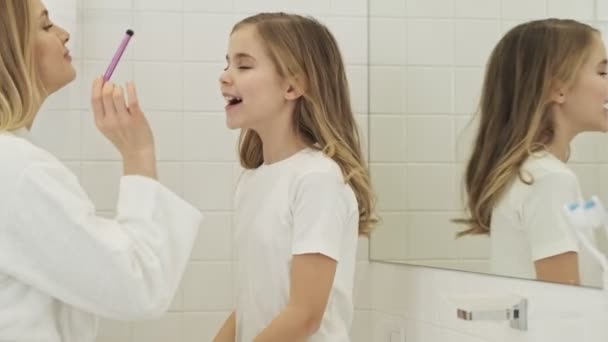 Young Mother Applying Makeup Her Lovely Little Girl Bathroom Morning — Stock Video