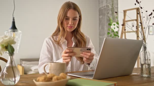 Een Gelukkige Jonge Vrouw Speelt Digitaal Spel Haar Smartphone Tijdens — Stockvideo