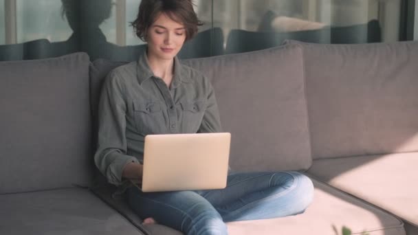 집에서 소파에 노트북 컴퓨터를 사용하여 아름다운 여성을 가르치는 — 비디오