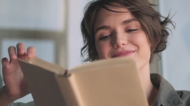 Piacevole Giovane Bella Donna Lettura Libro Mentre Seduto Sul Divano — Video Stock