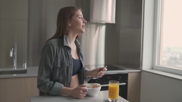 Μια Ελκυστική Έγκυος Γυναίκα Τρώει Πρωινό Κάθεται Στη Σύγχρονη Κουζίνα — Αρχείο Βίντεο