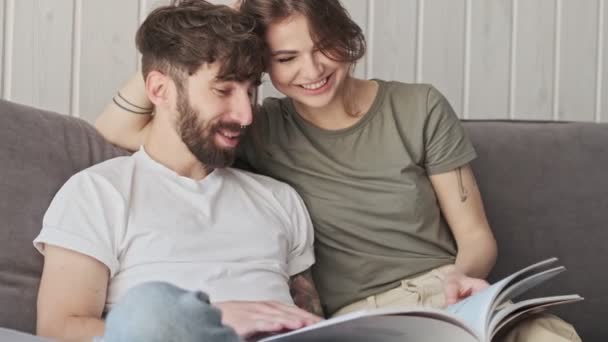 Romântico Casal Bonito Caucasiano Estão Sorrindo Lendo Livro Juntos Enquanto — Vídeo de Stock