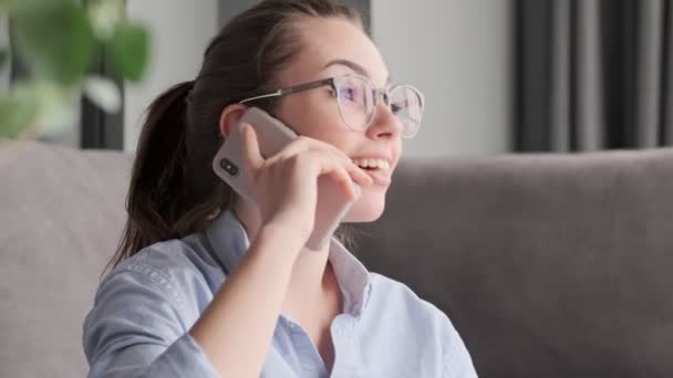 Szczęśliwa Atrakcyjna Brunetka Okularach Rozmawia Przez Smartfona Siedząc Podłodze Pobliżu — Wideo stockowe