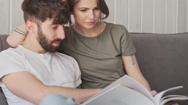 Jovem Casal Atraente Homem Mulher Estão Lendo Livro Juntos Enquanto — Vídeo de Stock