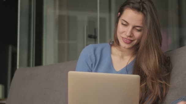 Una Mujer Sonriente Positiva Está Usando Computadora Portátil Mientras Está — Vídeo de stock