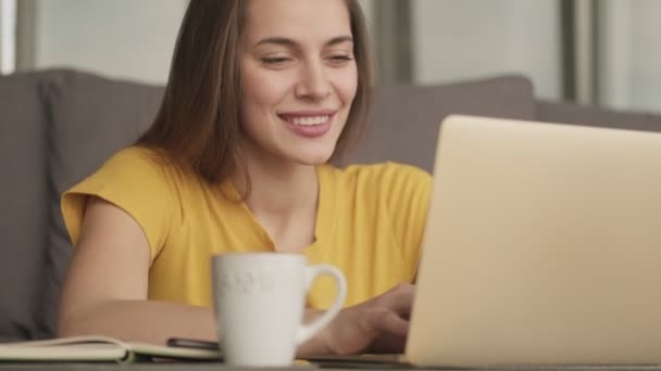 Щаслива Жінка Друкує Ноутбуці Сидячи Столом Вдома — стокове відео