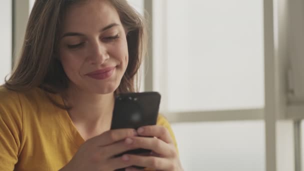 Una Joven Feliz Contenta Está Escribiendo Algo Teléfono Inteligente Casa — Vídeo de stock