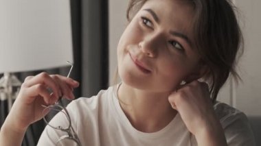 Pijama giyen güzel bir kadının yakın plan görüntüsü sabahları evdeki rahat bir odada oturuyor.