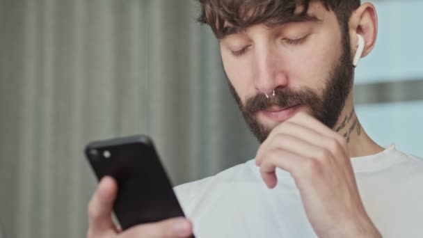 Close View Calm Young Hipster Man Earbuds Messaging His Smartphone — Stock Video