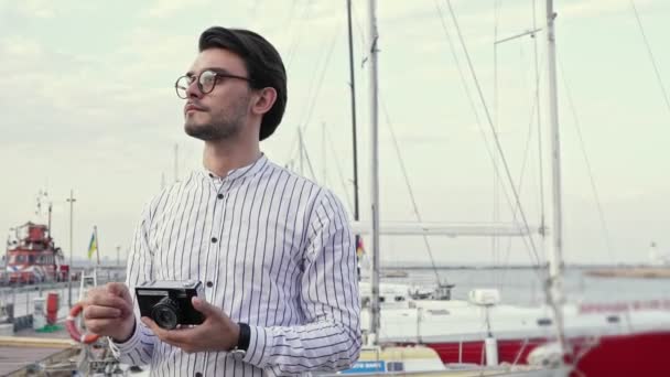 一个戴眼镜的英俊男子正在码头上拍照 — 图库视频影像